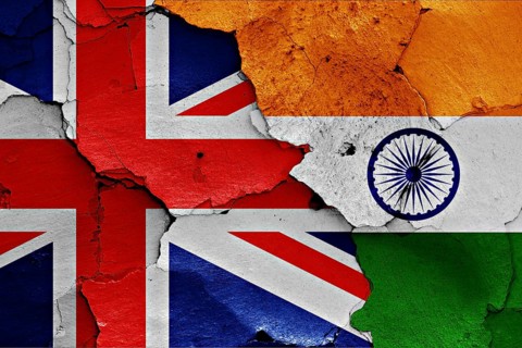 Flags of UK and India painted on cracked wall