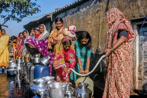 Women standing in queue to collect water in slum, Mumbai, Maharashtra, India, Asia