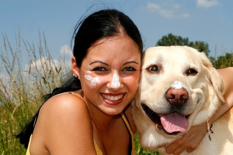 Woman and Labrador retriever with sun cream, sunscreen