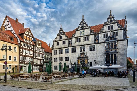 Historic square with half-timbered houses and classic buildings, under a cloudy sky, The historic