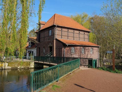 Brick mill with bridge, red roof and surrounding river, metelen, westphalia, germany
