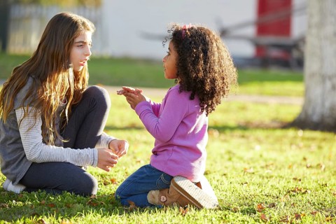 Kid girls playing in a park grass mixed ethnicity outdoors