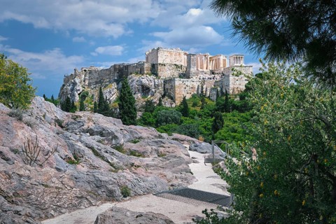 View of Acropolis hill from Areopagus hill in summer daylight with great clouds in blue sky,