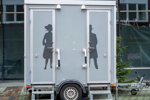 Modern portable toilet trailer with separate entrances for men and women, featuring elegant