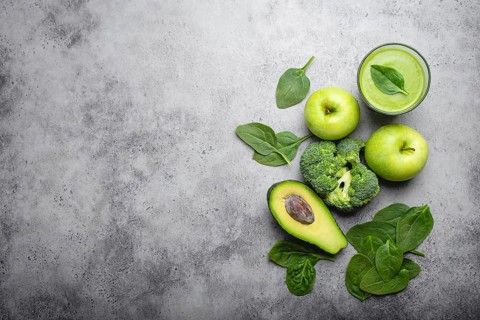 Ingredients for making green healthy smoothie with broccoli, apples, avocado, spinach, stone