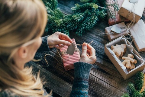 Eine unerkennbare Frau packt Weihnachtsgeschenke ein
