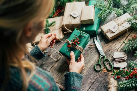 Unrecognizable woman decorating Christmas gifts