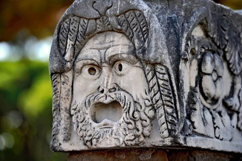 Ancient stone sculpture, stone carving of a mask, Roman theatre, ancient port city of Rome,