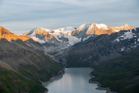 View at the summit of Mont de la Blana, alpenglow at sunset, view of a blue mountain lake, Lac des