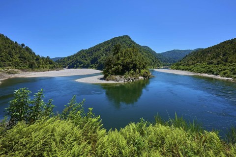 River bend with green mountains and lush vegetation under a blue sky, Kilkenny Lookout, Buller