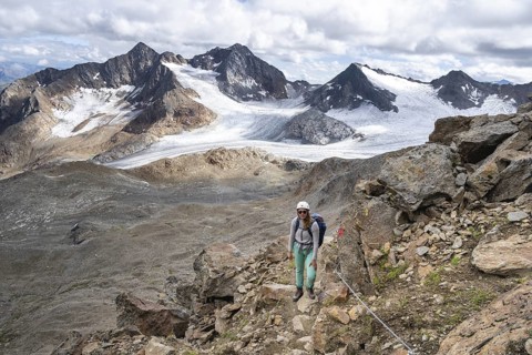 Mountaineer with helmet on a rope-insured path, in high mountain landscape, ascent to the Becher,