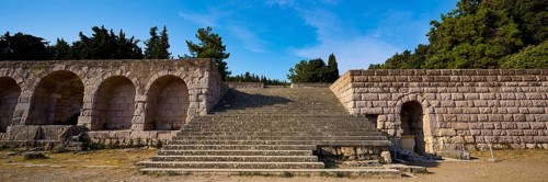 Panorama of a stone staircase and ancient structures with trees in the background, open staircase
