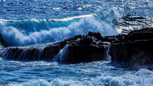Rugged rocky coastline and foaming spray, on Stecci beach, near Capoliveri, Elba Island, Tuscan