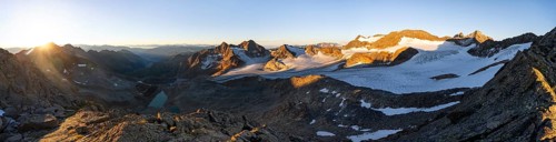 Picturesque high mountain landscape at sunrise with alpenglow, blue glacial lakes, glaciers and