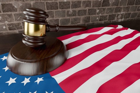 American flag and wooden gavel resting on desk