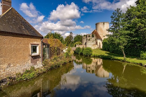 The river Loir and the castle with donjon in Alluyes, Centre-Val de Loire, France