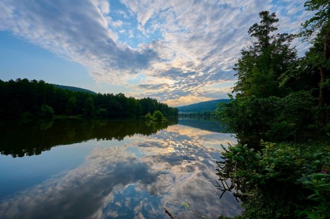 An impressive sky with clouds over a quiet, reflecting river at sunrise, summer, Grünenwört,