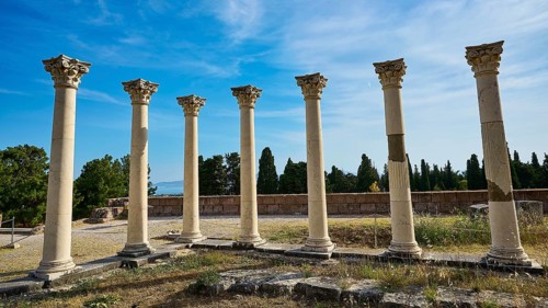 Arrangement of ancient columns against a natural backdrop and blue sky, Temple of Apollo,