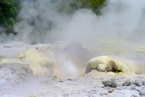 Yellowish sulphur deposit on volcanic rock formations with rising steam, Te Puia, Whakarewarewa,
