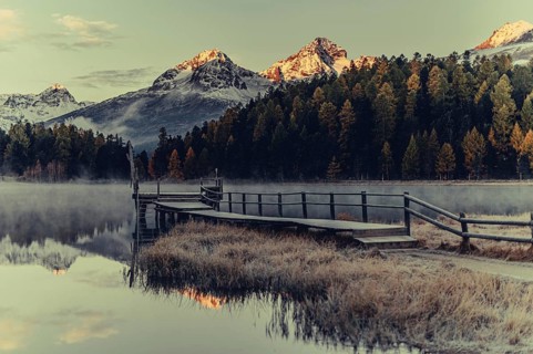 Lake Staz near Sankt Moritz in the Engadin in Switzerland. Morning atmosphere with fog in autumn.