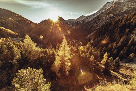 Woman sitting thoughtfully at a feslen at autumn atmosphere during sunset in the Swiss Alps in the