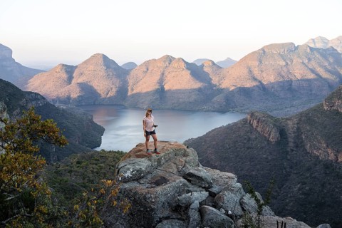 Hiker enjoying sunset at Blyde River Canyon, view of canyon with Blyde River in the evening light,