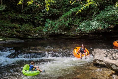 Visitors tubing down Deep Creek in the Smoky Mountains near Bryson City, North Carolina, USA