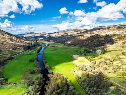 Farms and Mountains over River Dochart and Road A85 from a drone, Perthshire, Scotland, UK