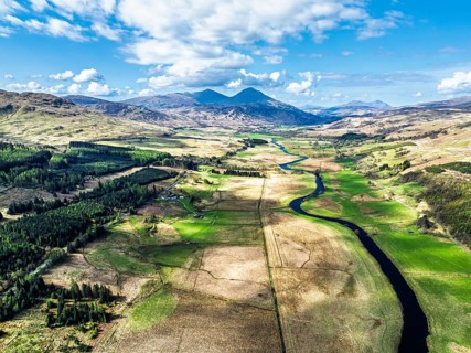 Farms and Mountains over River Dochart and Road A85 from a drone, Perthshire, Scotland, UK