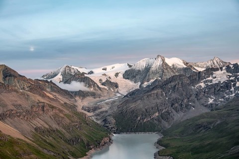 Mountain landscape with turquoise blue reservoir Lac des Dix and summit Mont Blanc de Cheilon, moon