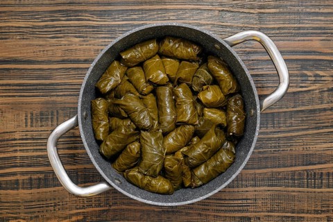 Each dolma is carefully rolled with seasoned rice and spices wrapped in grape leaves. The pot is