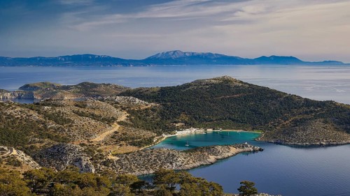 View of a coastal landscape with hilly vegetation and blue water, Holy Week, Bay of Panormitis,