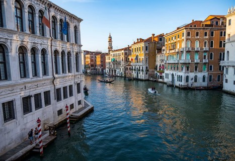 View of the Grand Canal with gondoliers at sunset, picturesque evening mood with palazzos on the