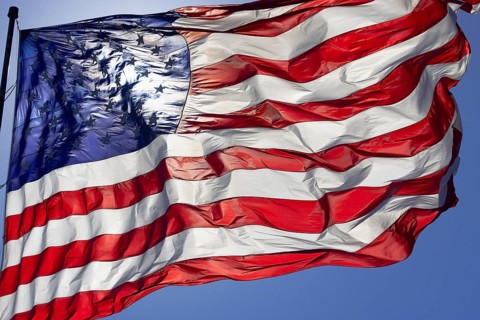 Dramatic backlit american flag waving in the wind