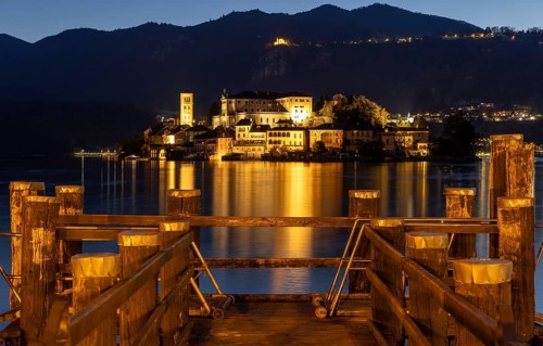 Wooden footbridge with view of Isola San Guilio, Orta San Giulio, on Lake Orta, Province of Novara,