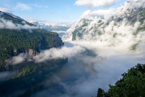View over the Geirangerfjord, atmospheric clouds over the fjord in the morning light, Ørnesvingen