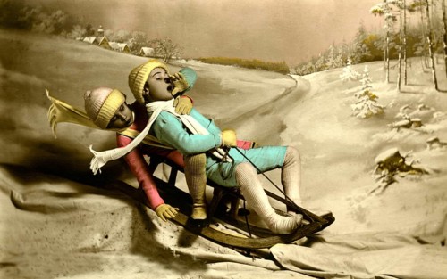 Two children sledding, 1930s, Two children in colourful winter clothing sledding in a snowy