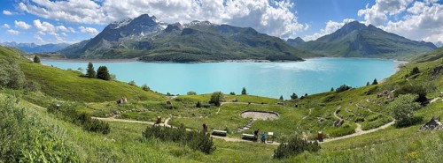 Panoramic view of Lac du Mont Cenis, in the foreground Alpine garden Jardin Alpin next to pass road