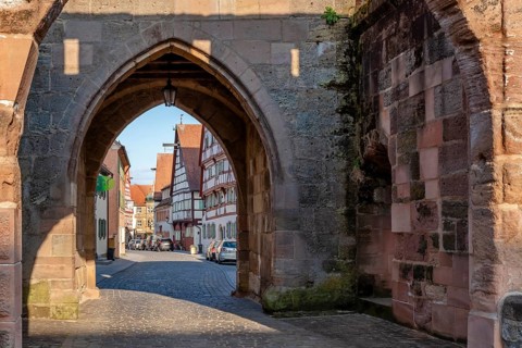 Alley with cobblestones leads through the town gate Oberes Tor, view through the gate to the