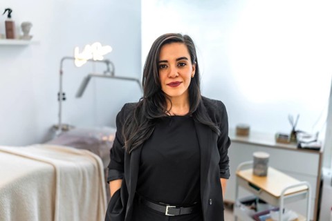 Young female beautician smiling in her beauty salon or hairdressing aesthetic center, wearing
