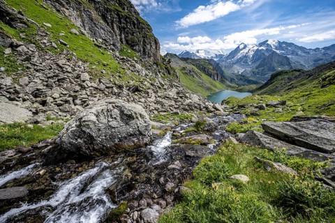 Mountain stream in picturesque mountain landscape, view of mountain lake Lac du Louvie and
