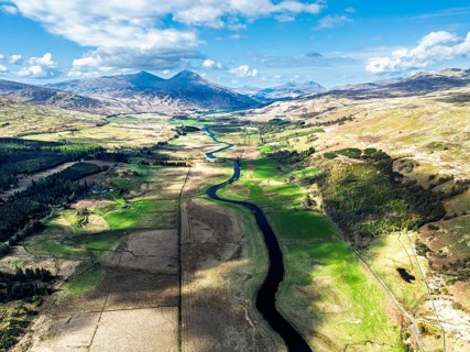 Farms and Mountains over River Dochart and Road A85 from a drone, Perthshire, Scotland, UK