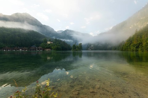 Mystical morning at Königssee in Schönau with boathouses and Christlieger. Sunrise and beautiful