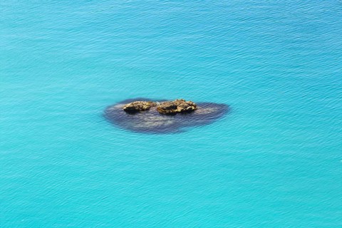 Small group of rocks in the turquoise-coloured sea with calm water, Ricadi, Capo Vaticano