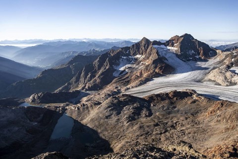 Picturesque high mountain landscape at sunrise, glacier and rocky mountain peaks in the morning