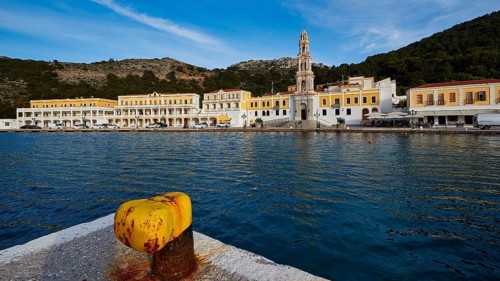 View over the harbour to the monastery with a striking tower and yellow buildings, Holy Week, Bay