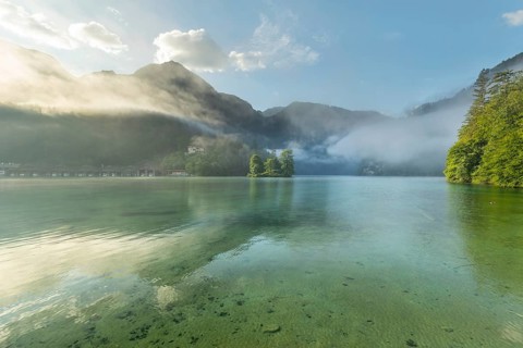 Mystical morning at Königssee in Schönau with boathouses and Christlieger. Sunrise and beautiful