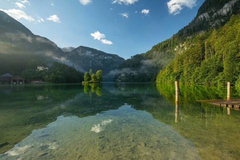 Mystical morning at Königssee in Schönau with boathouses and Christlieger. Sunrise and beautiful