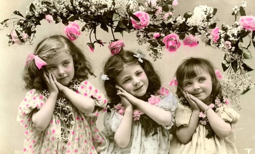 3 girls with flowers, 1900, Three girls in old-fashioned clothes with flowers and pink decorations,