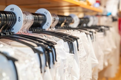 White shirts on hangers with size labels in a shop, focus on the size display, Sindelfingen,